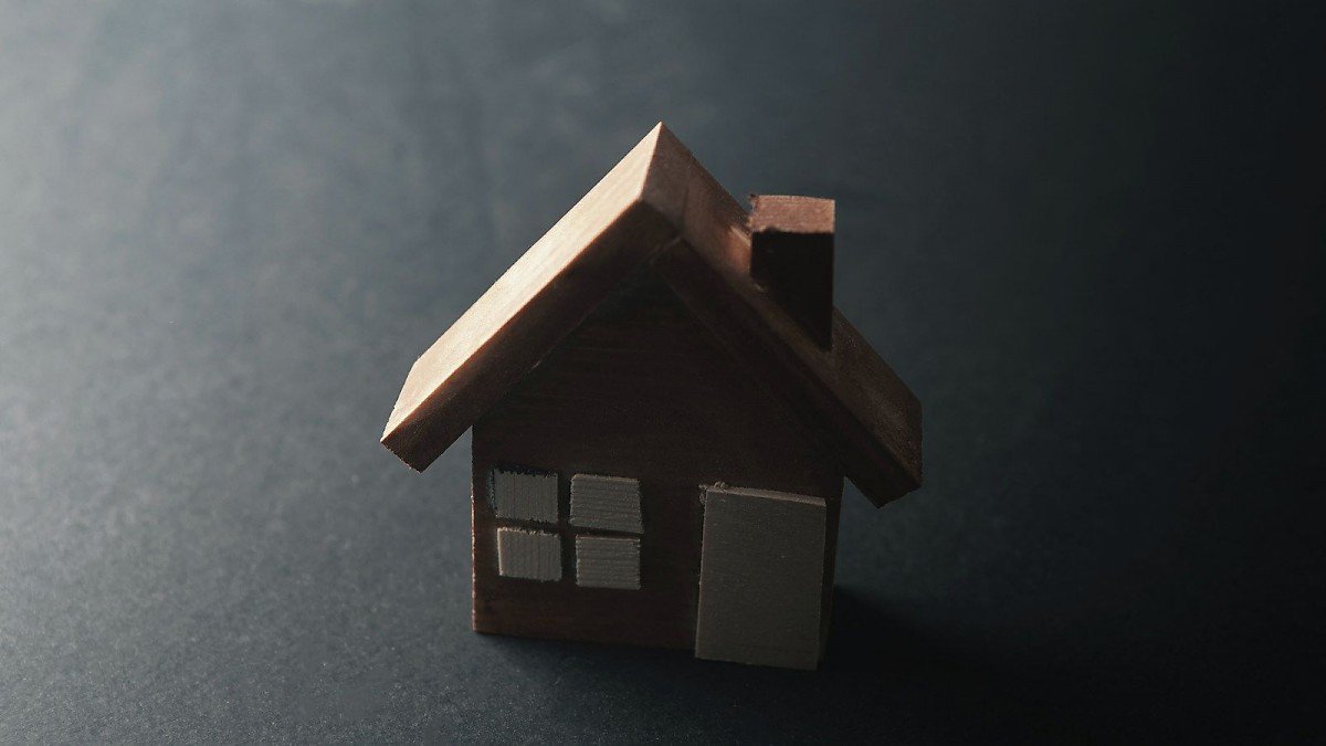 Hausmodell aus Holz auf dunklem Grund